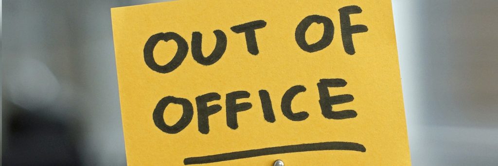 Out of office written on a post-it note