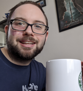 Nick smiling holding a large cup of tea