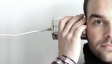 Man listening to a can on a string phone